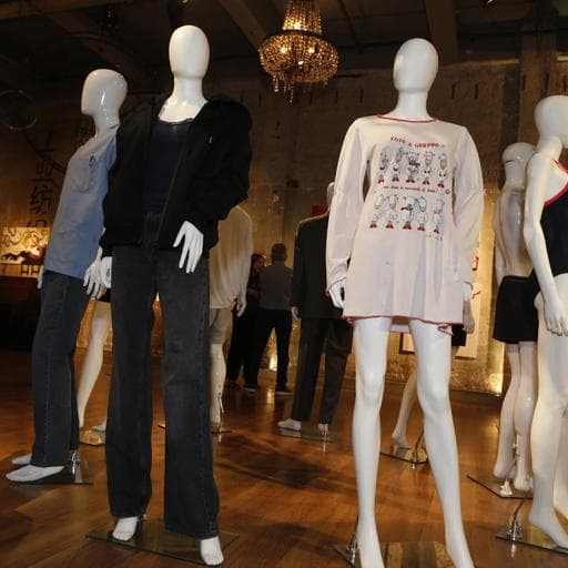Mannequins displaying casual clothing including jeans and graphic nightshirt in gallery.